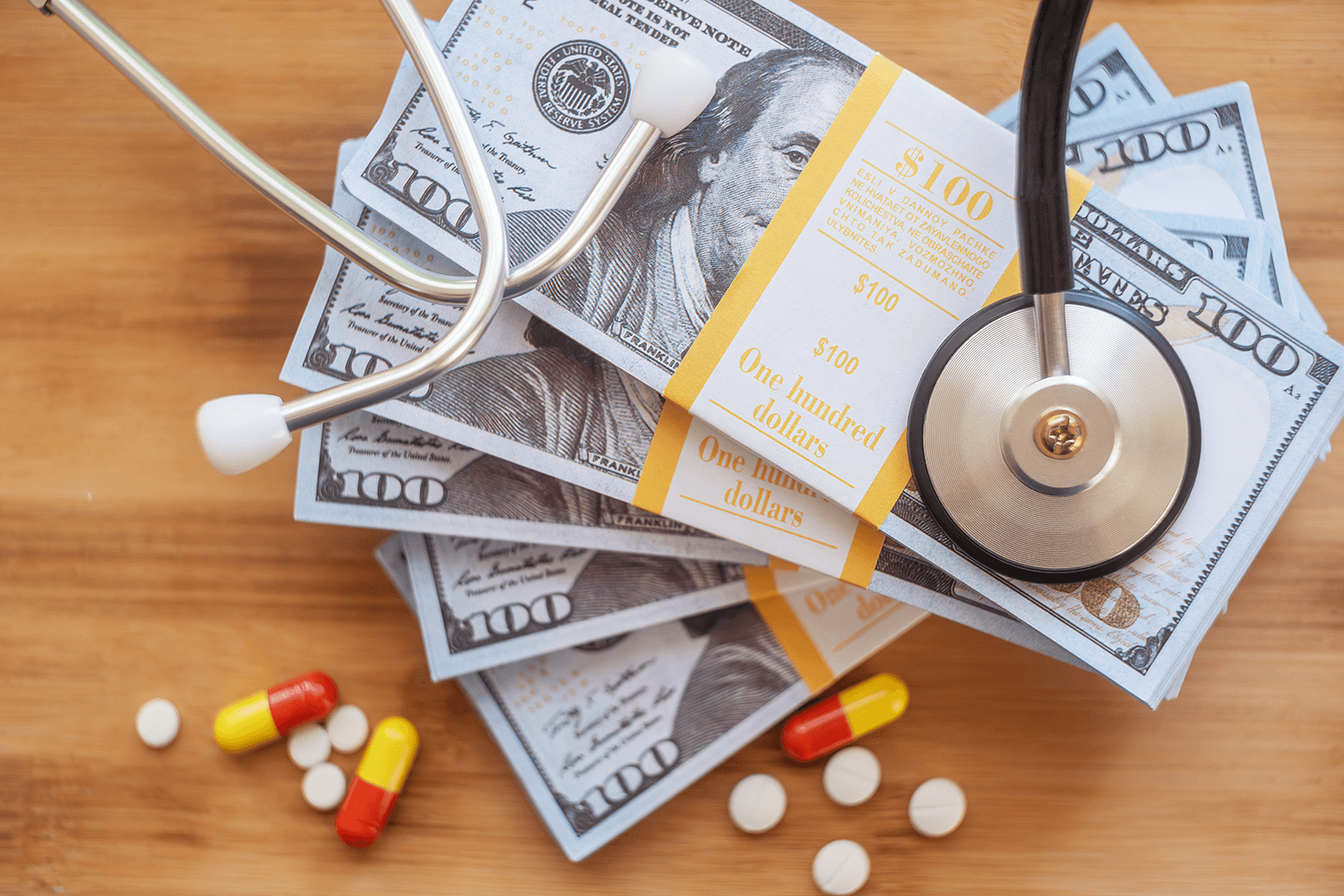 stethoscope resting on stack of cash symbolizing rising health insurance costs in the United States